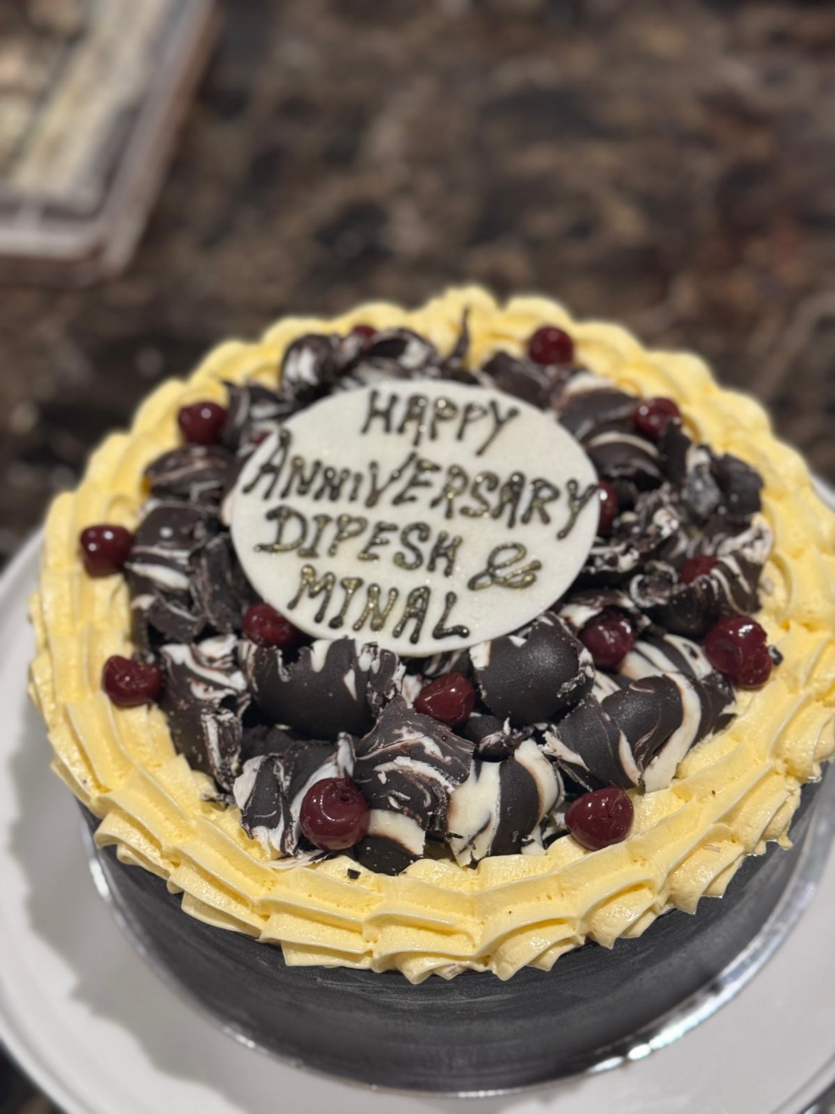 Chocolate anniversary cake with cherry and cream frosting