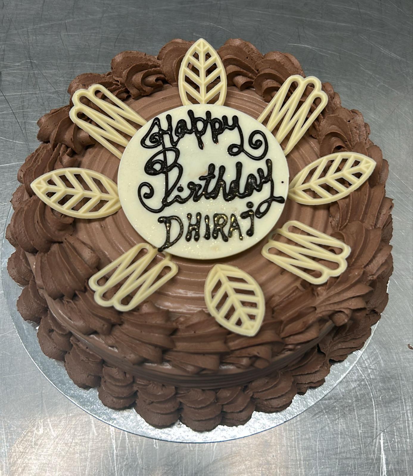 Signature dark chocolate truffle cake with white chocolate leaf decorations from Pastryology Petone