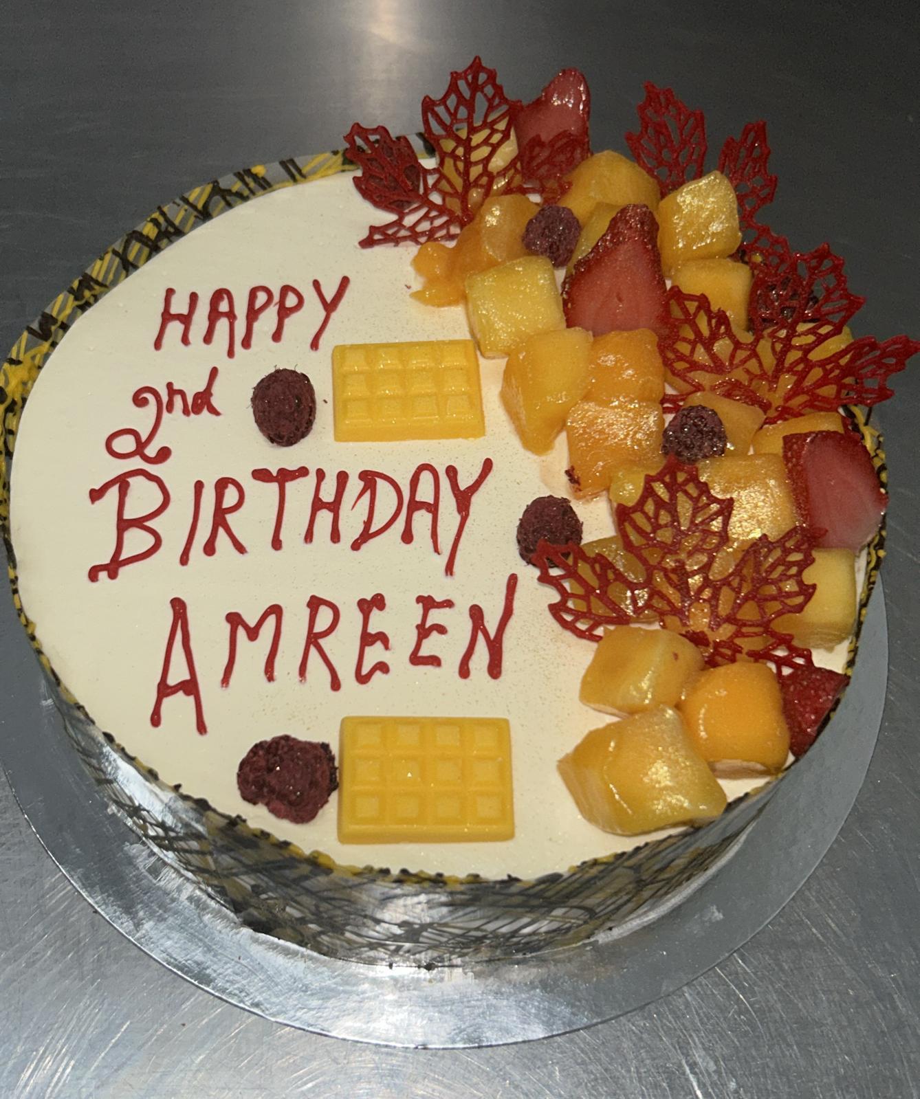 Fruit topped birthday cake with mango pineapple and raspberries