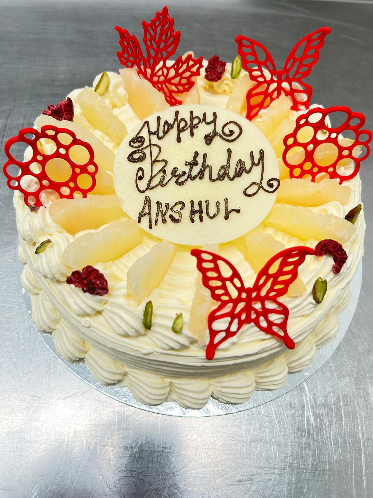 Personalised birthday cake with pineapple cream and red decorations